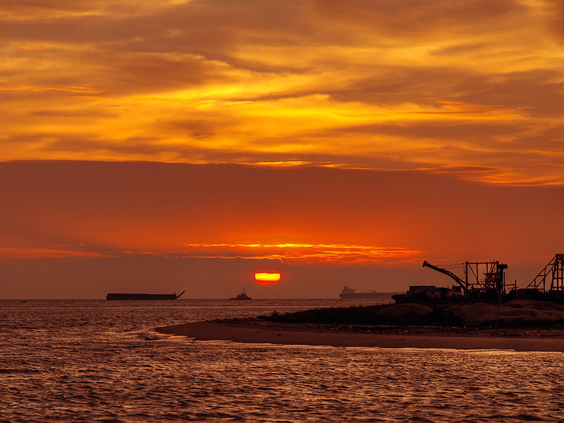 埋め立て地が沖に向かってどんどん伸びていくマラッカ海峡に沈む夕陽