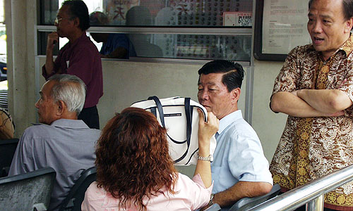 シンガポールのタクシースタンドで、相乗りの乗客を待つお客さんとタクシードライバー